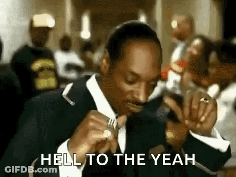 Snoop Dogg Is Eating A Piece Of Meat With A Fork In A Crowded Room . GIF