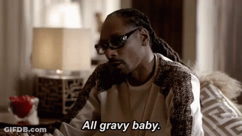 Snoop Dogg Is Sitting On A Couch In A Living Room Talking On A Cell Phone . GIF
