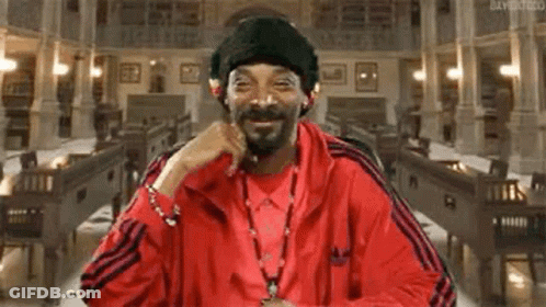 Snoop Dogg Is Wearing A Red Jacket And A Black Hat While Sitting In A Church . GIF
