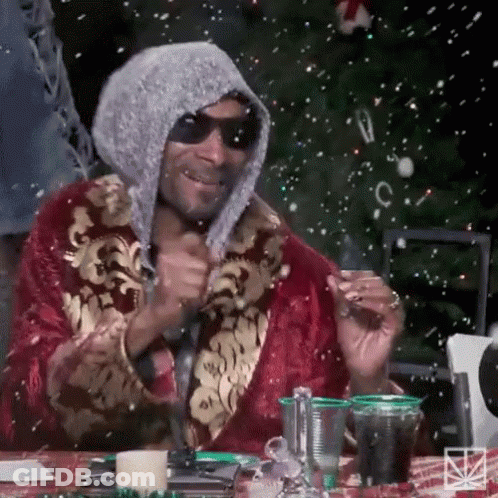 Snoop Dogg Is Wearing A Robe And Sunglasses While Sitting At A Table . GIF