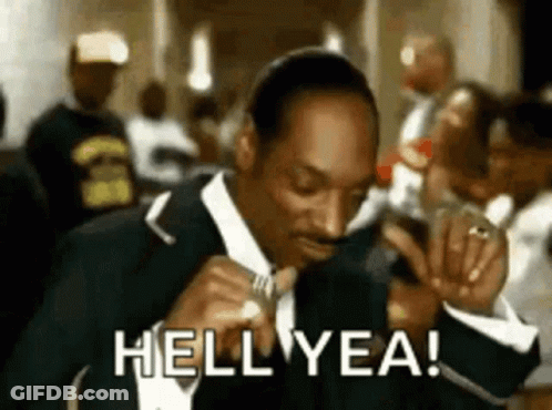 Snoop Dogg Is Wearing A Suit And Tie And Smoking A Cigarette While Saying Hell Yea . GIF