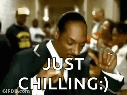 Snoop Dogg Is Wearing A Suit And Tie And Smoking A Cigarette While Saying `` Just Chilling '' . GIF