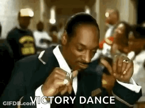 Snoop Dogg Is Wearing A Suit And Tie While Eating A Piece Of Food . GIF
