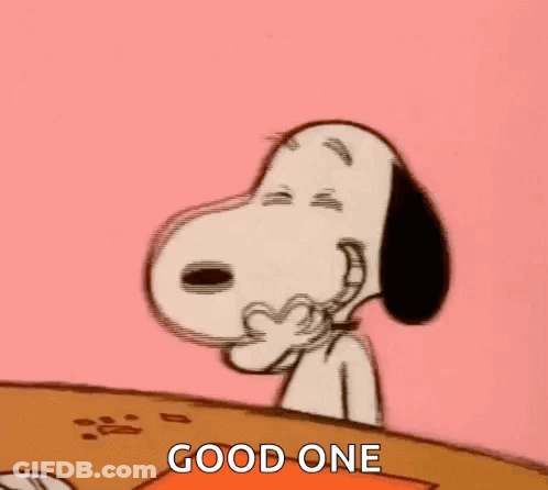Snoopy Is Sitting At A Table Covering His Mouth With His Hand And Laughing . GIF