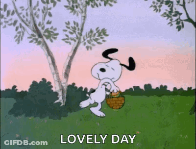 Snoopy Is Walking In A Field With A Basket And A Tree In The Background . GIF