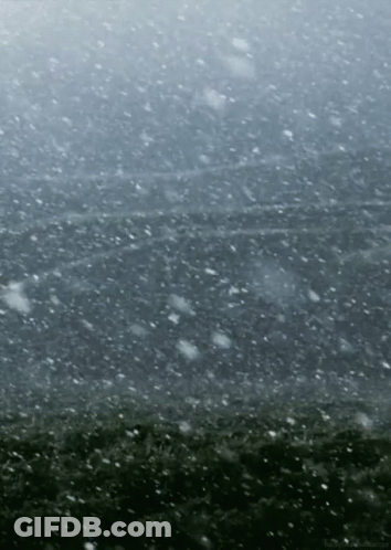 Snow Is Falling On A Dark Gray Background GIF