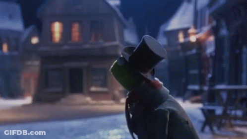 Snowman In Top Hat Standing In Snow In Front Of Building GIF