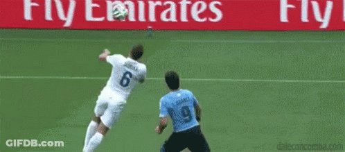 Soccer Goalie Jumping To Catch Ball While Player Blocks GIF