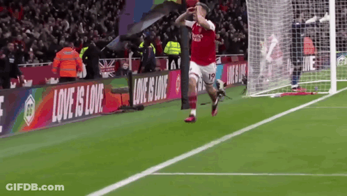 Soccer Player Celebrating Goal With Love Is Love Banner GIF