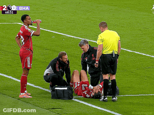 Soccer Player Helped By Doctor And Referee GIF