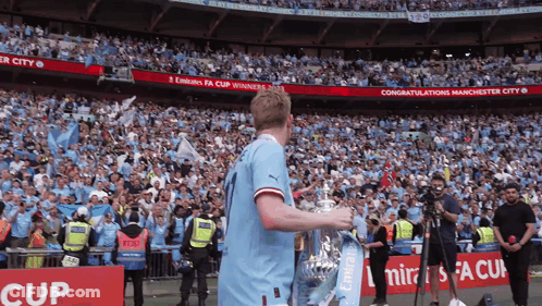 Soccer Player Holding Trophy In Crowd With Emirates GIF