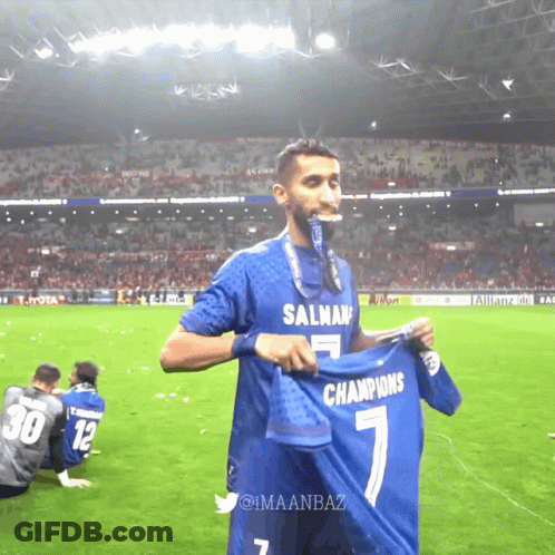Soccer Player Holding Up Shirt Saying Champions GIF