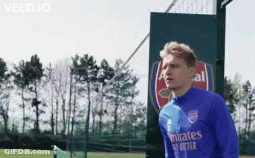 Soccer Player In Blue Emirates Shirt Standing In Front Of Sign GIF