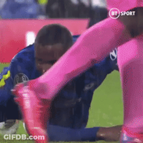 Soccer Player In Blue Tackled By Player In Pink GIF