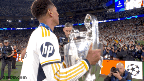 Soccer Player In HP Shirt Holding Trophy GIF