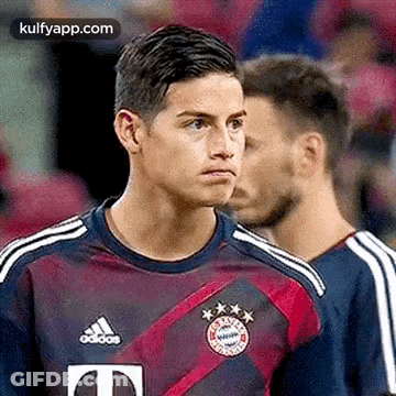 Soccer Player In Purple And Red Adidas Jersey Standing Next To Player GIF