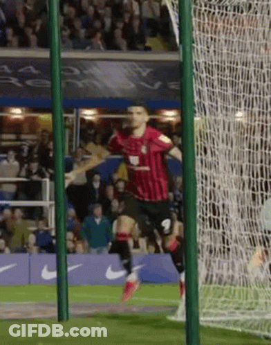 Soccer Player In Red And Black Celebrating Goal GIF