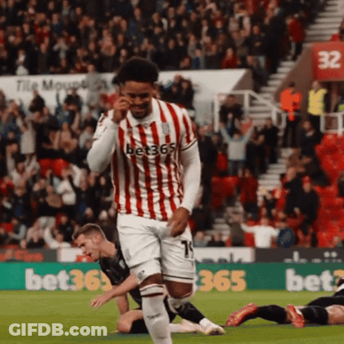 Soccer Player In Red And White Jersey Running Past Birmingham Van Centre Ad GIF