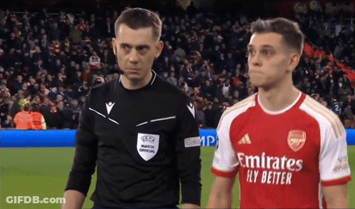 Soccer Player In Red Emirates Fly Better Jersey Next To Referee GIF