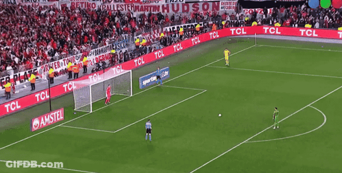 Soccer Player In Red Jersey And White Gloves Standing In Front Of Goal GIF