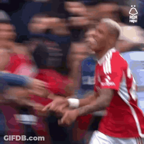 Soccer Player In Red Jersey Shaking Hands With Fan GIF