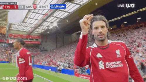 Soccer Player In Red Standard Chartered Jersey Celebrates Goal GIF