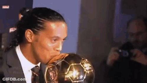 Soccer Player In Suit Kissing Ball GIF