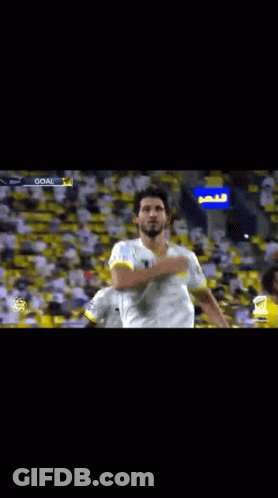 Soccer Player In White And Yellow Jersey Raising Arm GIF