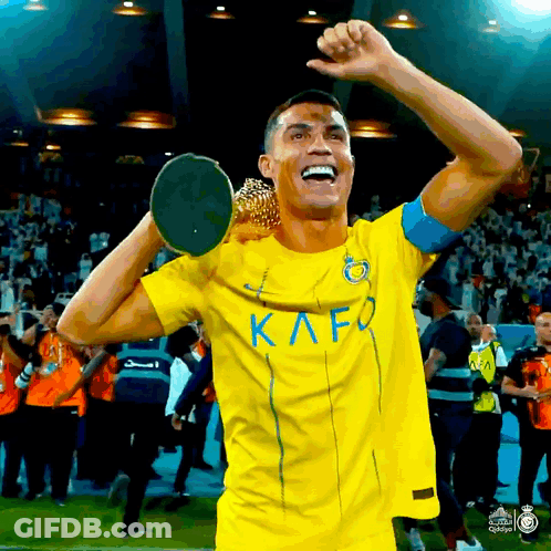 Soccer Player In Yellow Kafo Jersey Holding Trophy Over Head GIF