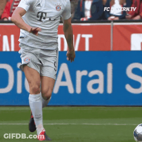 Soccer Player Kicking Ball In Front Of Aral S Sign GIF