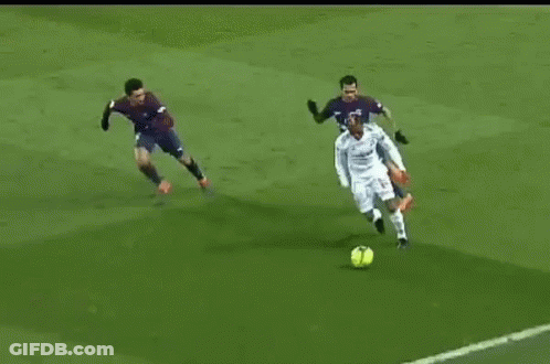 Soccer Player Kicking Ball While Defender Tries To Stop GIF