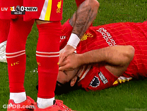 Soccer Player Laying On Ground Being Helped Up GIF