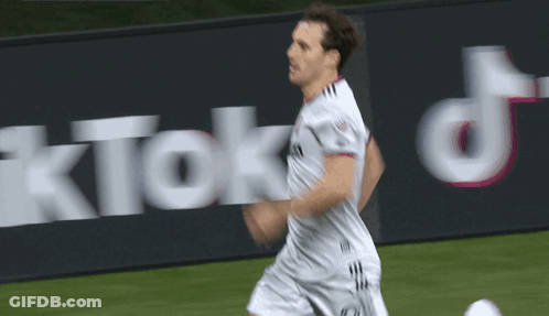 Soccer Player Running In Front Of TikTok Sign GIF