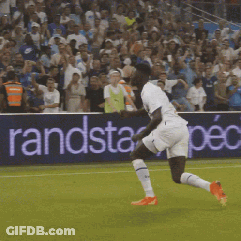 Soccer Player Running On Field With Randstad Spec Banner GIF