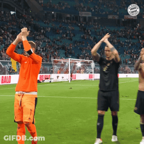 Soccer Players Applauding On A Field With A Big Bald Ad Behind Them GIF