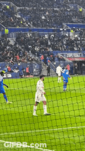 Soccer Players Behind Net With Crowd In Stands GIF