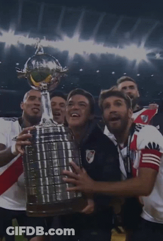 Soccer Players Holding Trophy Together GIF