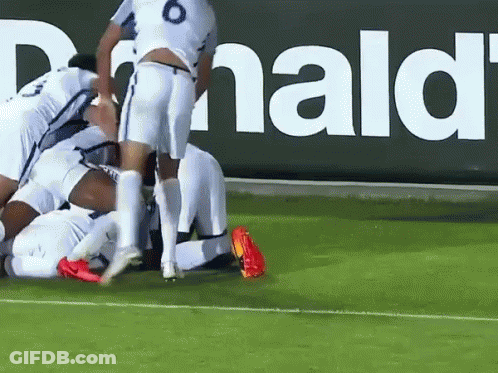 Soccer Players Huddled In Front Of McDonald's Sign GIF