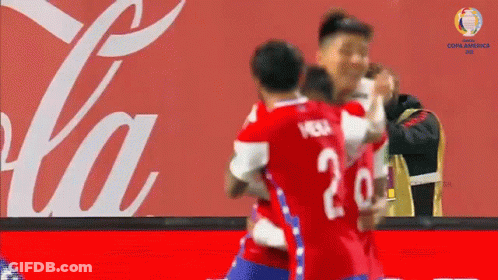 Soccer Players Hugging In Front Of Coca Cola Ad GIF