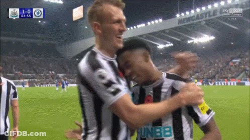 Soccer Players Hugging In Front Of Newcastle Sign GIF