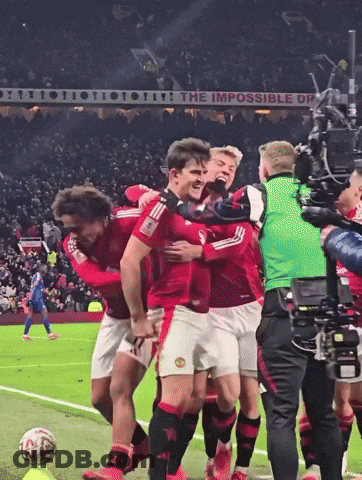 Soccer Players Hugging In Front Of The Impossible Dream Sign GIF