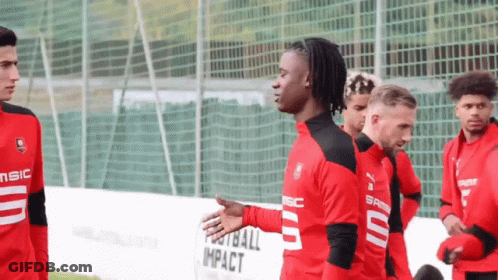 Soccer Players In Front Of Football Impact Fence GIF