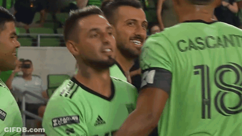 Soccer Players In Green Jersey Number 18 Hugging GIF