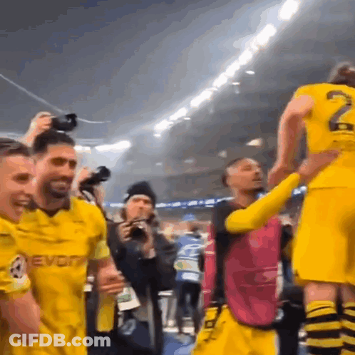 Soccer Players In Yellow Jerseys Celebrating Victory GIF