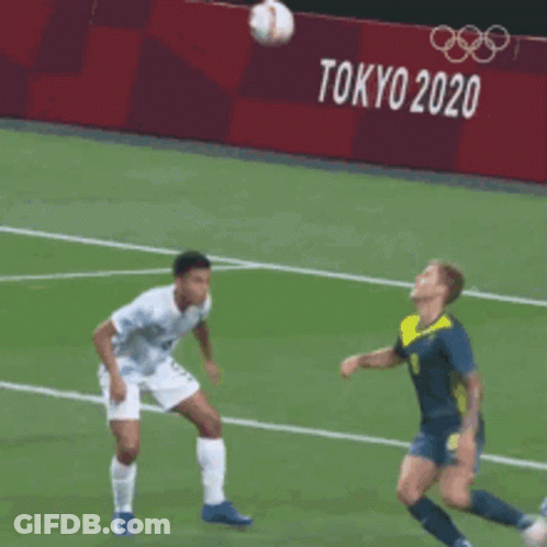 Soccer Players On A Field With A Tokyo 2020 Sign Behind Them GIF
