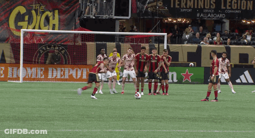 Soccer Players On Field In Front Of The Gaich Sign GIF