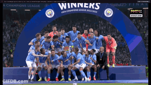 Soccer Players Posing Under Winners Banner GIF