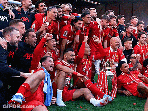 Soccer Players Posing With Trophy And Standard Chartered Shirt GIF