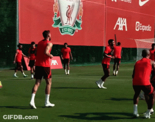 Soccer Players Practicing In Front Of Red Axa Expedia Sign GIF