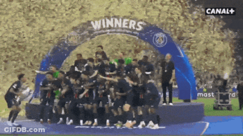 Soccer Players Standing Under Winners Banner GIF